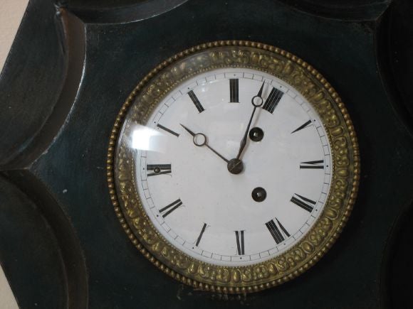 A beautiful dark green tole clock with gilt and enameled dial.