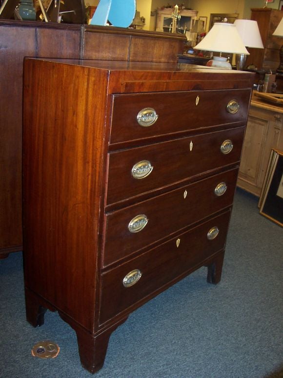 This richly colored antique chest of drawers is an unusual and interesting size. It is taller than it is wide, and it is rather narrow in depth.  Also unique in the 4-drawer configuration.  The chest has its original ivory escutcheons and graceful