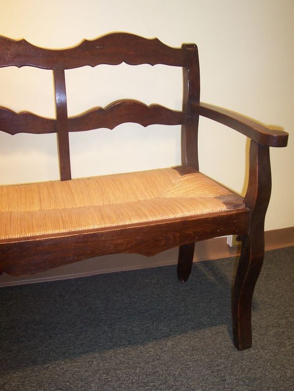 Beautifully shaped rails on a charming antique French rushed seat bench.  Sturdy seating.