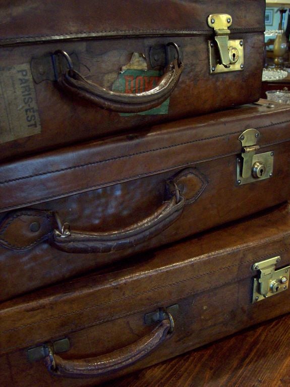 A fabulous stack of three antique leather suitcases from England. The rich luggage brown leather is buttery in feel, and the smallest one even has destination stickers! Measurements are given for the stack; individually they measure 28 x 15 x 7, 26