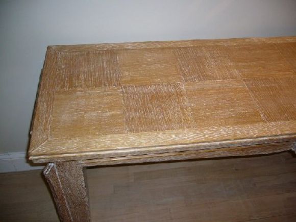 Limed oak console table with tapered legs and checkerboard design on table top.