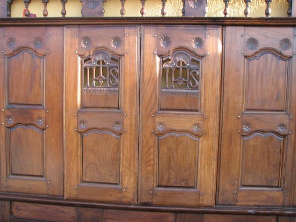 Hand carved panel with two (2) sliding doors used for an enclosed bed (lit clos) that was found in a rectory in Brittany. The piece was hand-made for a priest; each sliding door bears the letters I.H.S, the Christogram 
