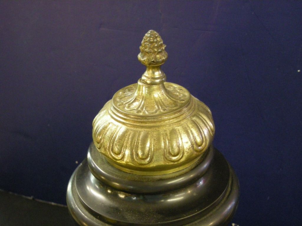 Continental neoclassic-style gilded metal and marmo belgio temple, with reeded columns surrounding a classical figure. The gilded metal temple top is decorated with an acorn finial and sits atop an onyx circular base.