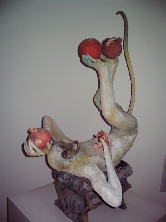 Original clay sculpture by Lois Hennessy featuring a very whimsical monkey reclining on a bench eating pomegranates.  Monkey lifts off bench and pomegranates are removable. Signed by artist on leg of bench.