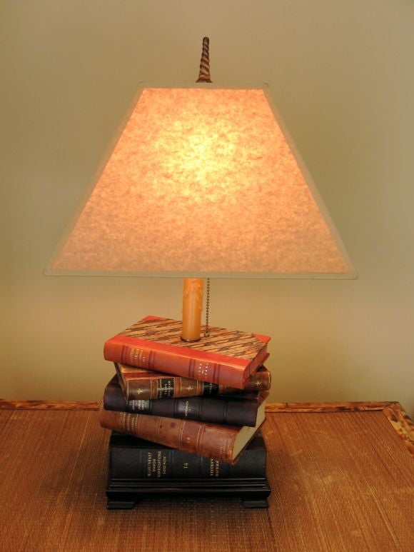 Pair of book lamps comprised of old Scandanavian books with leather bindings.  Books are mounted on wood base with antique finish hardware.  Newly wired.  Shades are a deep beige paper in rectangular form.  Height given is with shade.  Height