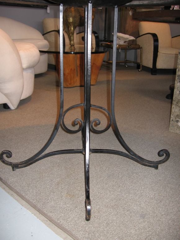 Mirrored table on wrought iron base.  Mirror is aged, with a design that looks like woven cane. Mirror is surrounded by an antiqued gold border.