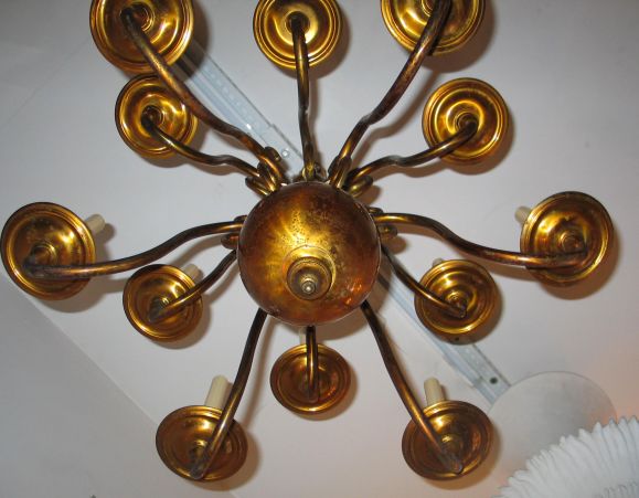 Un lampadario classico, sobrio e italiano di metà secolo in ottone massiccio con 12 bracci su due livelli centrati intorno a una grande sfera in ottone.

L'altezza di 30