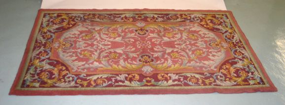 Two hand-knotted French rugs attributed to Aubusson with a Classic interlacing design of acanthus leaves. Very lively color tones in pinks, reds, yellows and a pink/green border. 

The rugs are a pair but are available individually.