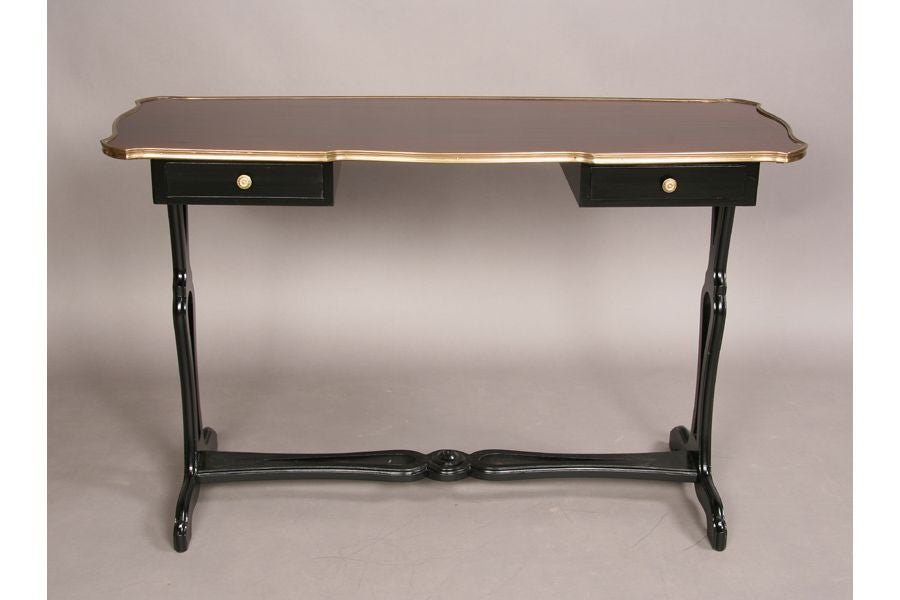 Rare French mid-century console table / writing table or desk by Maison Jansen incorporating modern and neoclassical elements. The piece features and ebonized base and a Macassar ebony top. Solid brass banding surrounds the top and adds to the