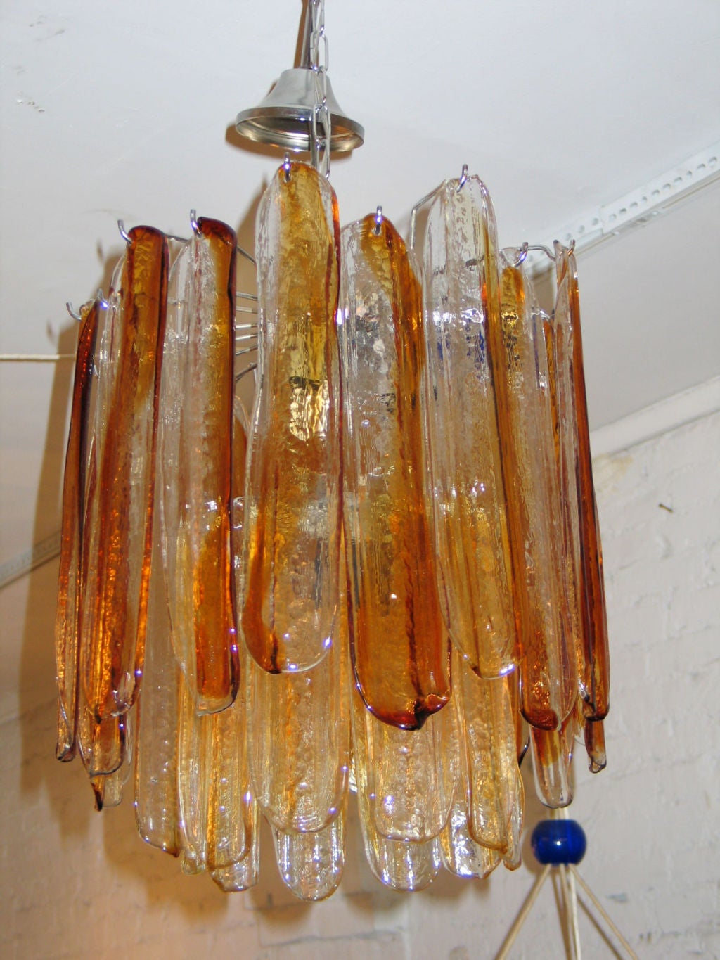 Italian Mid-Century Modern amber colored glass chandelier handblown in Murano by Mazzega. This Piece has a double layer of glass and imparts a warm light. The inner layer has ten pieces and the outer layer has 24 long pieces with both forming an
