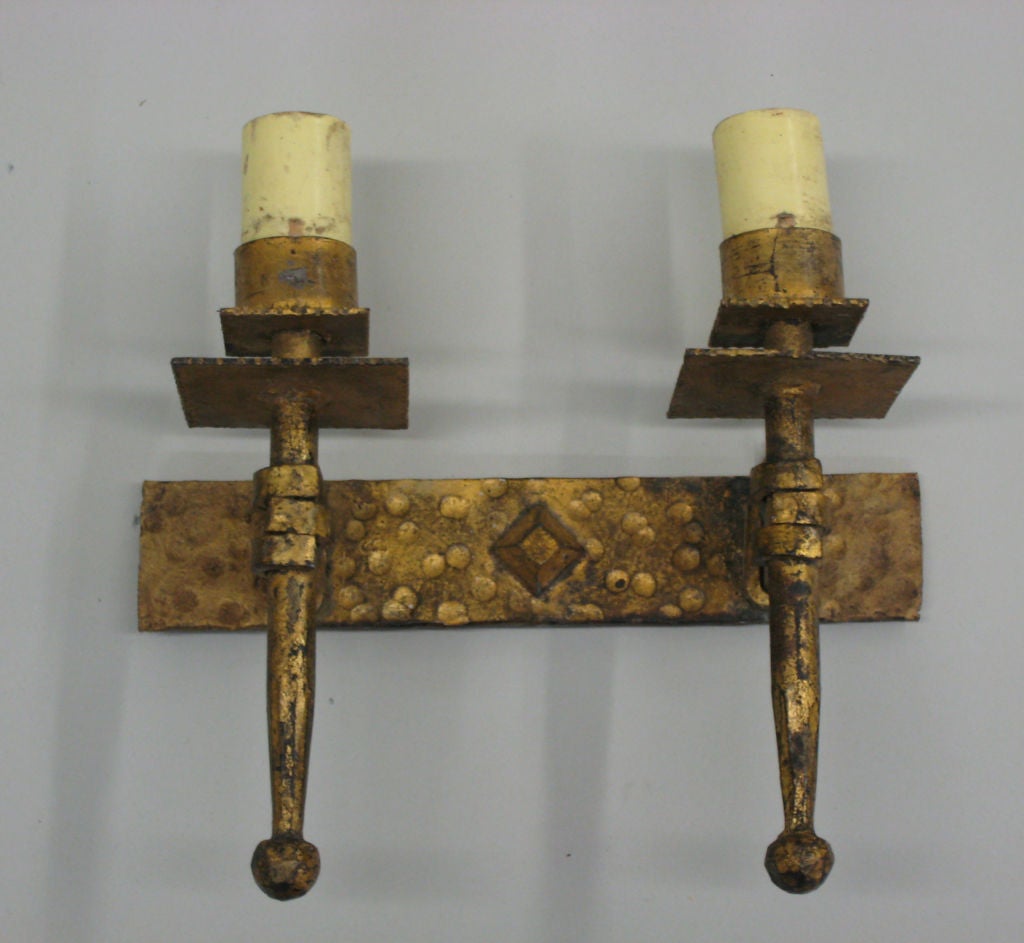 Two pairs of French Mid-Century Modern Neoclassical, gilt iron wall lights in the style of Gilbert Poillerat, each with double arms. 

Price and Sold as Individual Pieces.