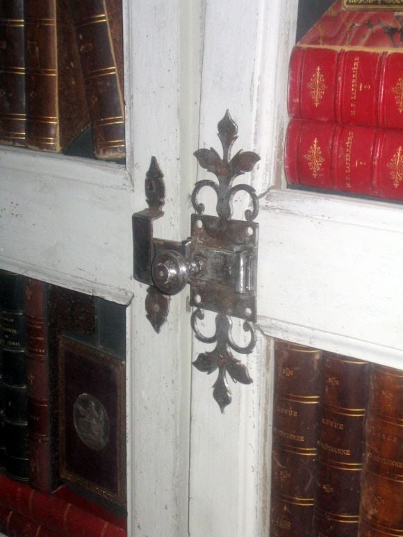 A fabulous pair of 18th century French doors with French 19th century leather books Inset into the Panels. The composition is meant to function either as a Decorative screen or doors. A silver lock-plate is able to open or close them (if desired).