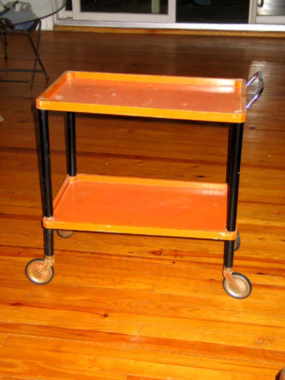 Original Bauhaus Era Double Level Drinks Cart. This Chic Early German Modern Piece is Made of Wood Lacquered Orange with Black Laquered Legs and Rubber and Steel Wheels.