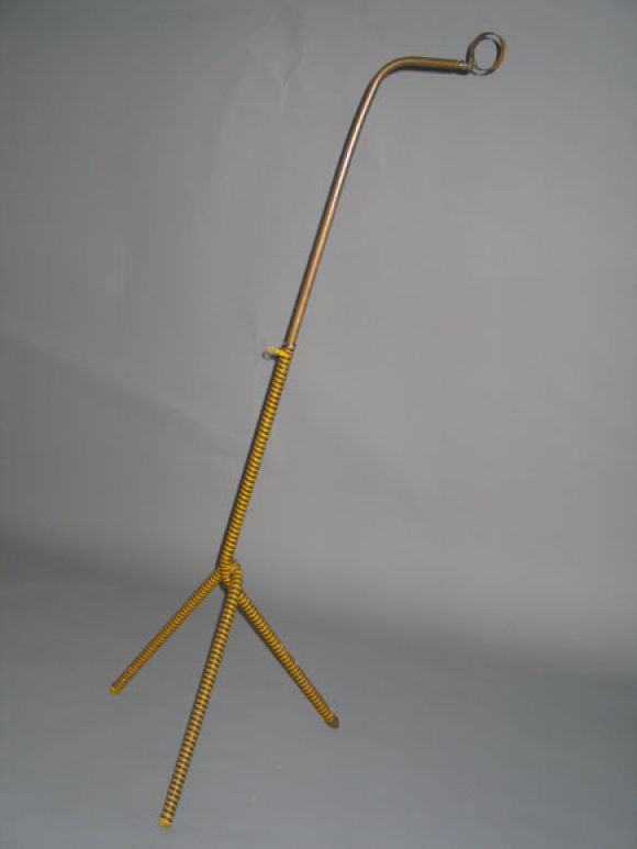 Elegante lámpara de pie modernista con forma dinámica en voladizo y patas de trípode con la base envuelta en ratán plástico azul y amarillo alternados. Se muestra sin sombra. La altura es ajustable. 

Referencias adicionales: Jean Royere diseñó