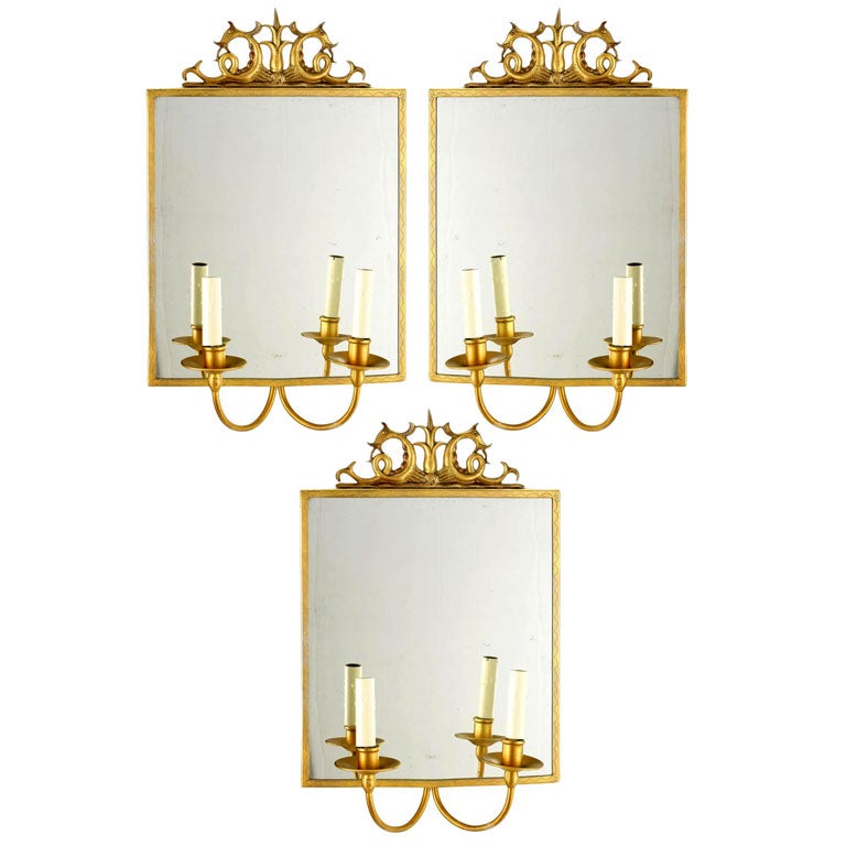 A rare Swedish Mid-Century Modern Neoclassical gilt pewter wall light / mirror / girandole with two-arm sconces attached. 

The top of the frame is decorated with a sculpture of a single lotus flanked by two mythical sea creatures symbolizing the