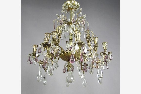 Elegant brass and cut crystal chandelier by Baguès for Jansen in the modern neoclassical taste having a cut and etched glass central baluster surrounded by an opulent dressing of amethyst and clear cut and faceted pendaloques, cabochons and