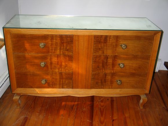 A Stylish French Late Art Deco / Mid-Century Modern commode, dresser or chest of drawers attributed to Rene Drouet, France, circa 1940-1950. This cabinet is outfitted with warm, matched walnut veneers on the front panels and is mirrored on its top