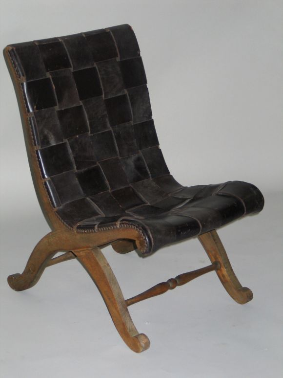 A single Spanish midcentury leather strap slipper chair in black leather with each strap interlaced with each other. The beautiful lines and form convey the modern neoclassical spirit.

Pierre Lottier was a French designer living in Barcelona,