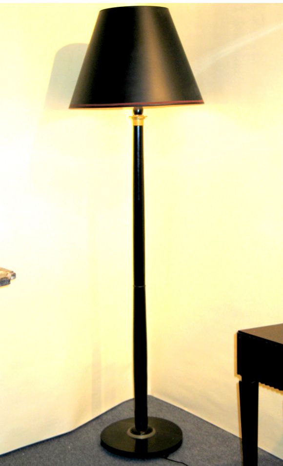 Elegant and sober French, 1930s Modern neoclassical/late Art Deco ebonized floor lamp with gilt bronze details surrounding the base and top. The form of the lamp has an a soft, sensuous line.

Shade is for demonstration purposes only.