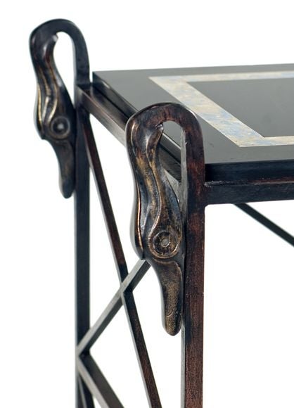 An important double-tiered table of iron and bronze with swan head motif and ball and claw feet by Marcel Coard (1889-1975). Later plateaus of slate, upper plateau inset of blue-grey scagliola. Stamped and numbered by the foundry of Marcel Coard.