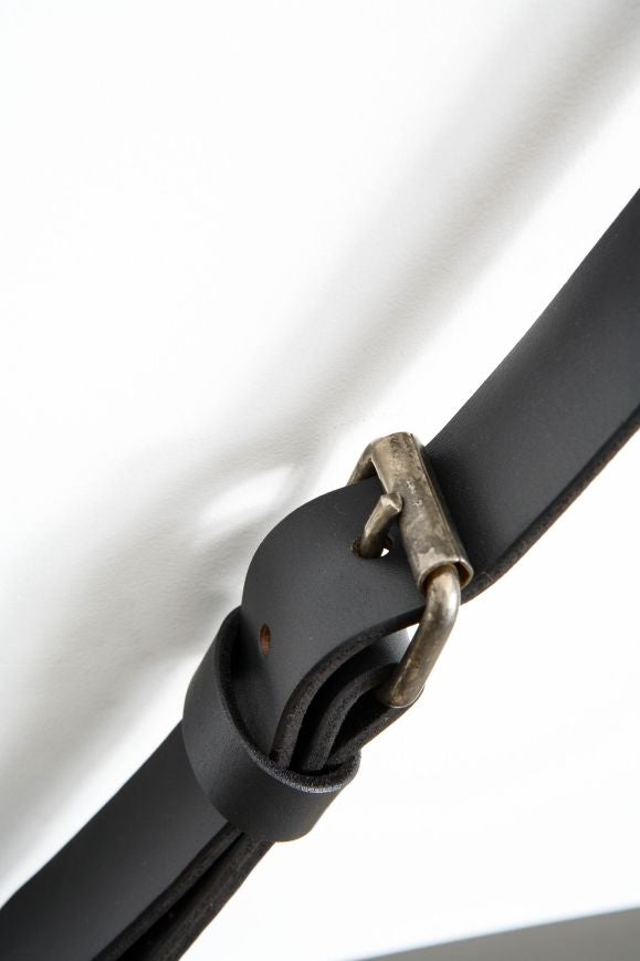 Black matte oxidized finish with brass accents hung with leather buckled strap.  Mirror measures approximately 57