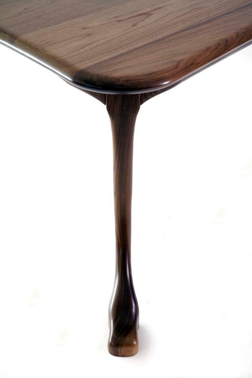 Solid walnut dining table.  Legs are removable from surface.  Beautifully curved lines.  Also available in solid teak.  Designed by William Emmerson and available exclusively through Ralph Pucci, Intl in the US.  Please inquire for pricing.