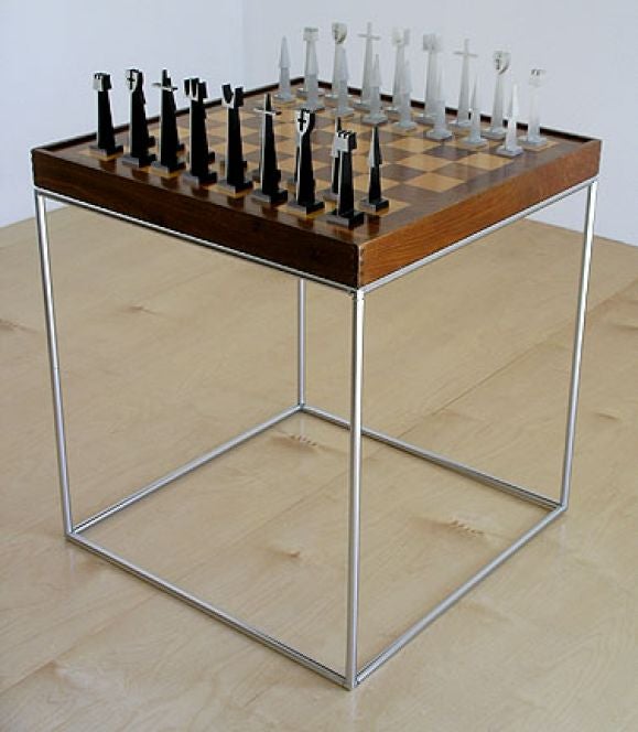 Chess set with chess table. Machined aluminum chess pieces made by Austin Enterprises 1962. Game table was purchased with the chess set. Included is the original wood and acrylic box to hold and display chess pieces. Table measures: 21 by 21 by 23