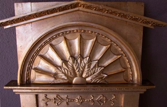A handsome Swedish empire giltwood mirror with pointed pediment above a splayed fan motif with foliate carving; the split mirror flanked by ribbon and reed columns