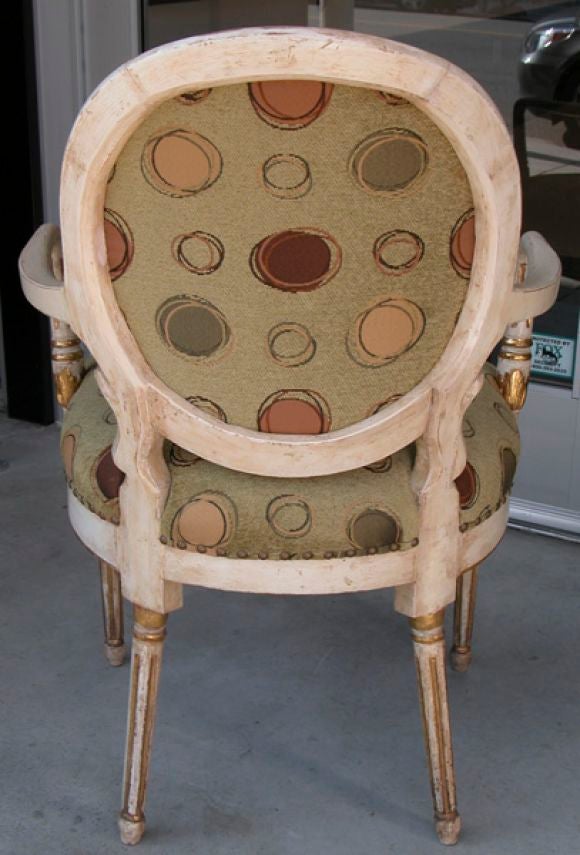 A handsome Swedish neo-classical ivory painted and parcel-gilt oval back armchair raised on fluted supports