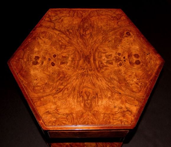 A diminutive and richly-figured pair of American 1940's hexagonal burl walnut veneered side tables; each with hexagonal top of mirrored, well-figured burl walnut veneer above a deep apron; raised on a turned, fluted splayed support over a similar