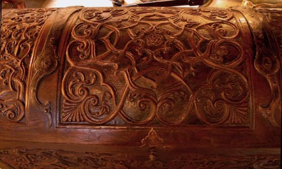 A large and well-carved French regence oak chest with domed lid; the rectangular domed lid with interlacing tracery relief carving; the body with similar foliate carving surrounding a charging hunting dog and stag; fitted with bold iron hinges and