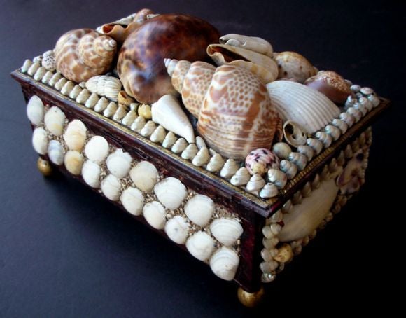 A charming American Victorian tramp art shell encrusted jewelry box; the rectangular lid over a conforming body adorned overall with various sized sea shells; the interior fitted with compartments and mirror