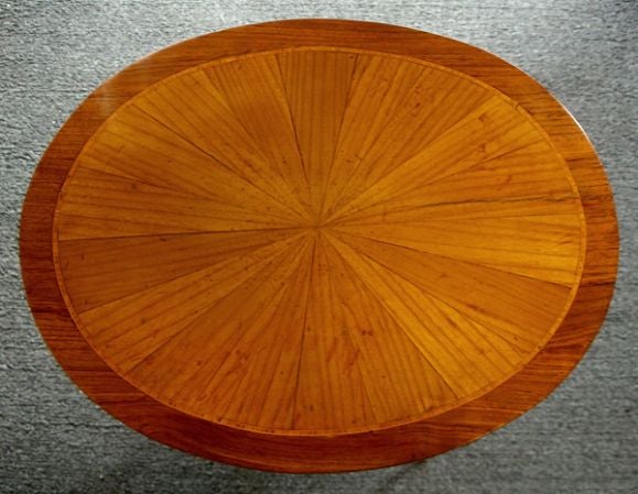 A diminutive French transitional Louis XV pearwood and walnut inlaid oval 3-drawer bouilotte table; the oval top with radiating pearwood veneer within a banded walnut border; the conforming body fitted with 3 drawers raised on slender splayed
