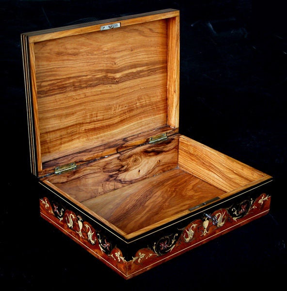 A finely inlaid Italian burl walnut rectangular box with classical designs and penwork detailing; the rectangular hinged top with a large reserve centering a classical krater-form urn flanked by winged griffins surrounded by foliate scrollwork;