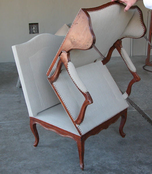 A rare and large-scaled French Louis XV fruitwood metamorphic chair transitioning into a chaise lounge; the cartouche back above a serpentine seat flanked by padded arms; raised on cabriole supports; the whole consisting of 3 hinged sections opening