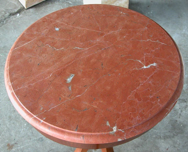 A graceful pair of Danish neoclassical style walnut circular tripod side tables; the circular top of rojo alicante marble with half bullnose edge above a plain frieze apron; raised on a turned graduated support raised on three splayed elegantly