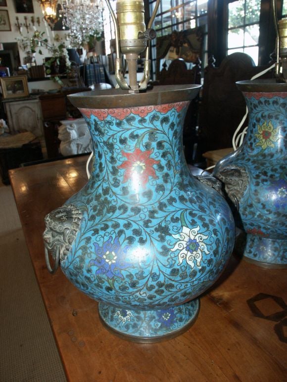 Beautiful pair of Antique lamps Ming Dynasty style,  each with globular contour supported on a flared foot and surmounted by a wide trumphet mouth, decorated with stylized lotus amid scrolling leagy tendrils on a turquoise ground,  the shoulder