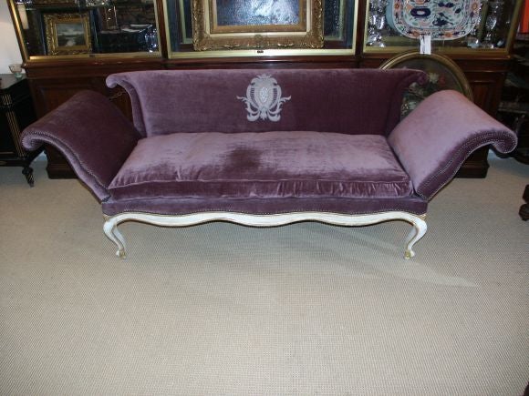 Great looking Italian style sofa with decorative crest and arms that can be lowered.  It has a later painted white  finish with hints of gold.