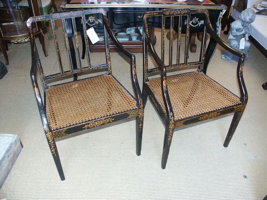 Beautiful pair of English cane seated and chinoiserie decorated arm chairs in black