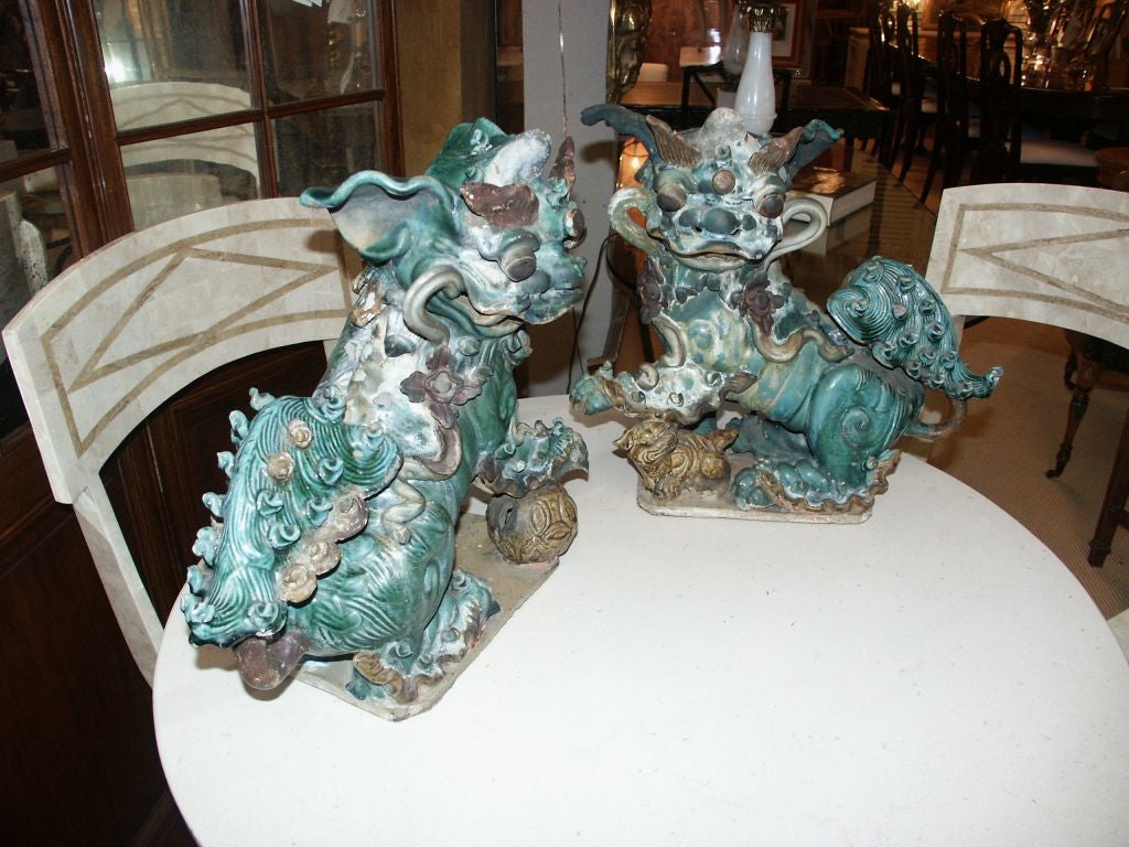 Great looking pair of ceramic roof tiles in the form of foo dogs with worn surfaces.