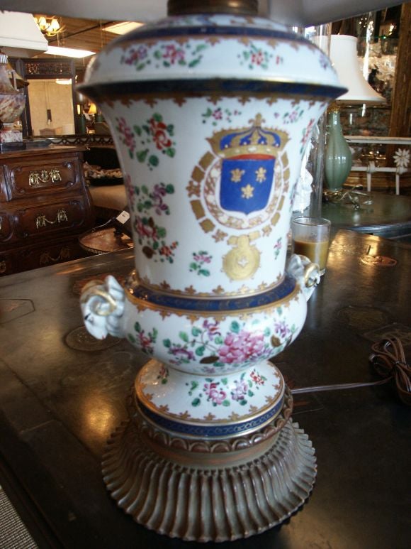 French porcelain made in lamp in the 20th C.  Great carved base and nice amorial decor on the porcelain.