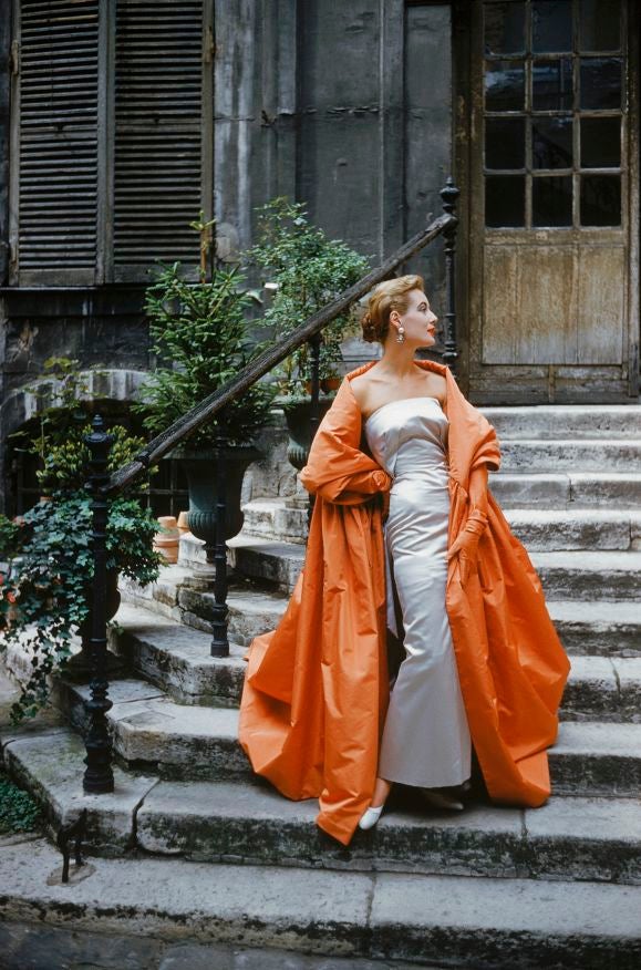 Shot in a Paris courtyard, a model descends a stone staircase wearing a Givenchy dress and cape, 1955. This image is an outtake shot by Mark Shaw for a fashion assignment for LIFE magazine and was never intended for publication. This work is