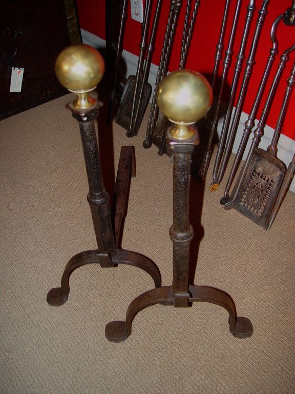 Elegant pair of 18th C English wrought iron andirons having penny feet and brass ball finials.