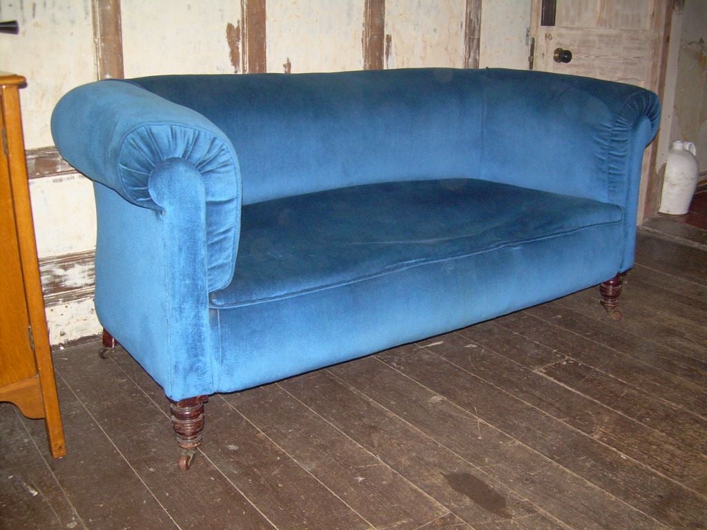 An English 19th century country house roll arm and back Chesterfield sofa having neat lines and proportions with high back on well-turned original legs having good color.
