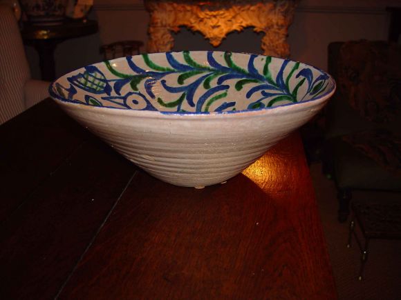 An early 20th c. Fajalauzan pottery bowl from Granada in Andalucia with muted blue and green decoration showing a stylized depiction of a peacock in leaves and flowers.  Beautiful colors.