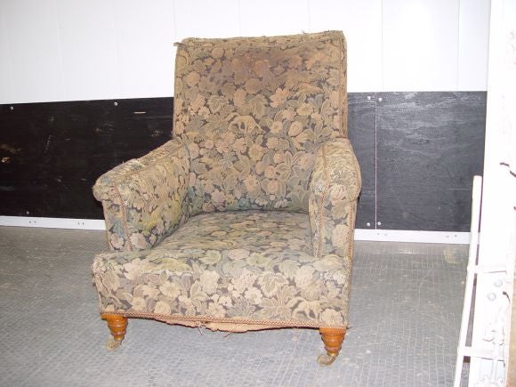 Original English 19th C club chair having rolled arms, comfortable cant to the back, on original turned maple legs and castors.