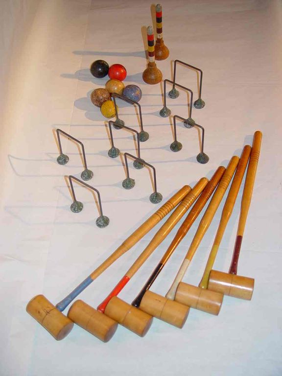 Miniature croquet set with six mallets and wooden balls in various colours, eight hoops and two multicoloured posts, for table top use.