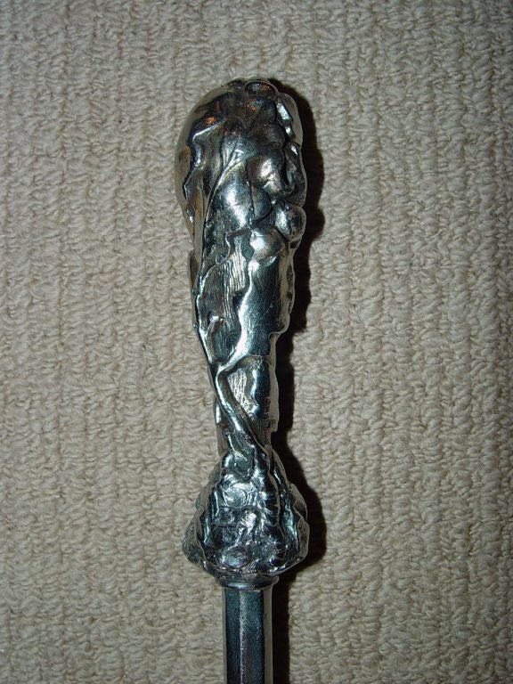 Un raffinato set di tre attrezzi da fuoco d'epoca georgiana composto da pala, attizzatoio e pinze, in acciaio lucido con manici in acciaio fuso dorato, pala piatta dalla forma unica con decorazione a foglie traforate.