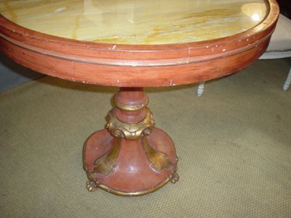 An unusual  polychrome table on hand-carved base