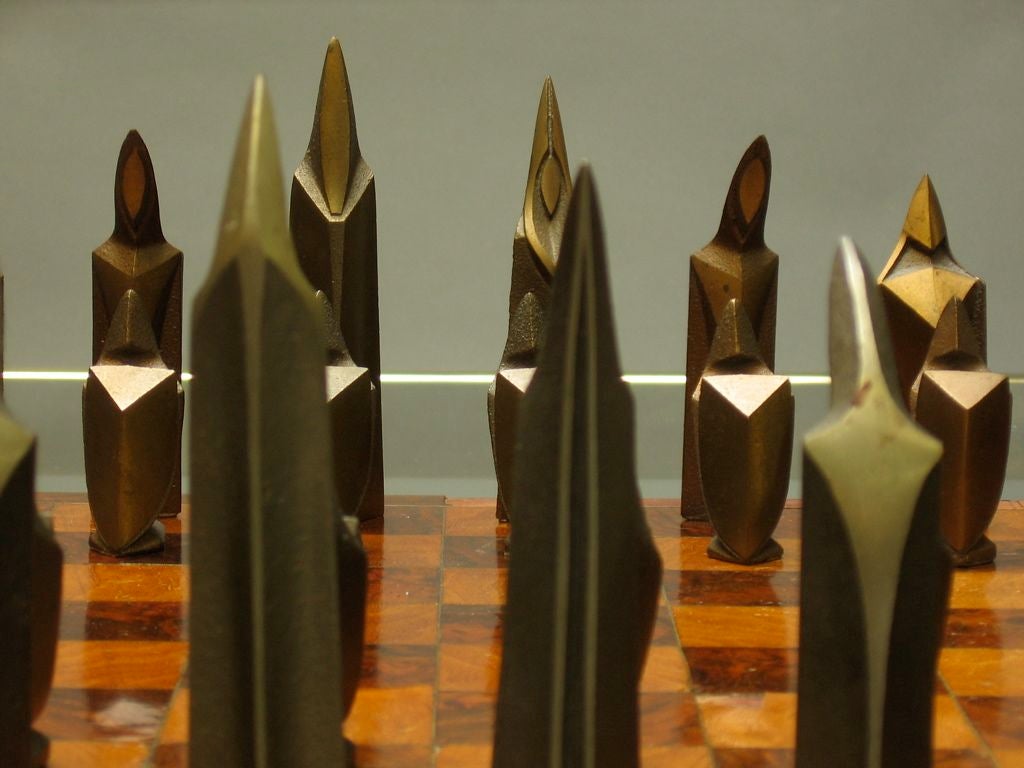 This is probably one of the best chess sets I've ever had, definately has some good age. Bronze game pieces rendered in the style of the Italian futurists (also reminiscent of Italian sculptor, Giacomo Manzu). Burlwood marquetry game board.